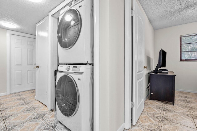 washroom with stacked washing maching and dryer and a textured ceiling