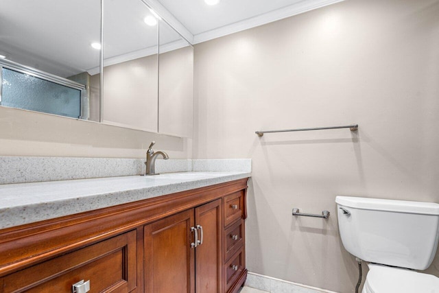 bathroom with a shower with door, vanity, crown molding, and toilet