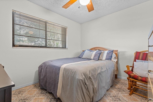 bedroom with ceiling fan and a textured ceiling