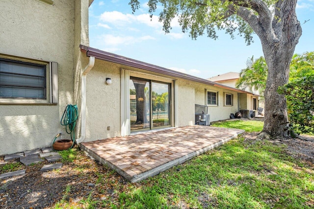 rear view of house featuring central AC unit and a patio area