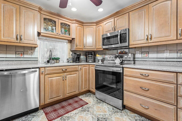 kitchen featuring ceiling fan, stainless steel appliances, sink, and decorative backsplash