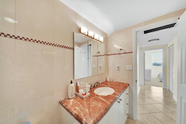 bathroom with tile patterned flooring, vanity, and tile walls