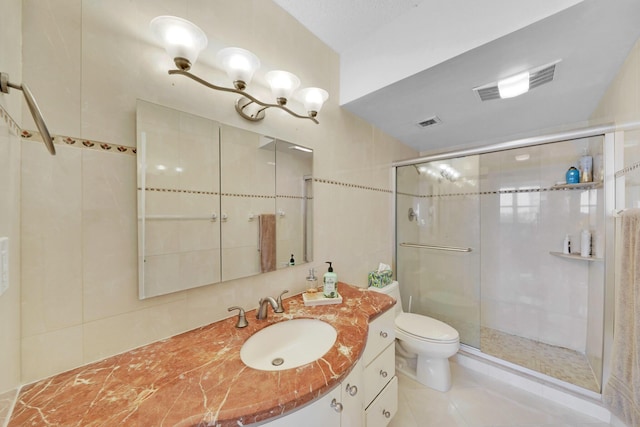 bathroom with vanity, toilet, tile patterned flooring, and a shower with door