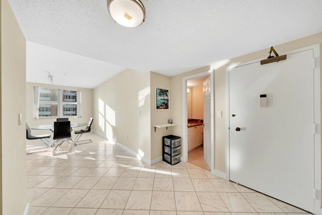 interior space featuring a textured ceiling and light tile patterned floors