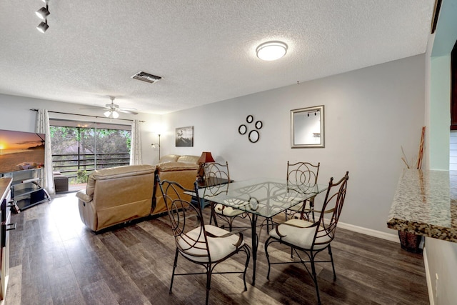 dining area featuring a textured ceiling, dark wood-type flooring, and ceiling fan