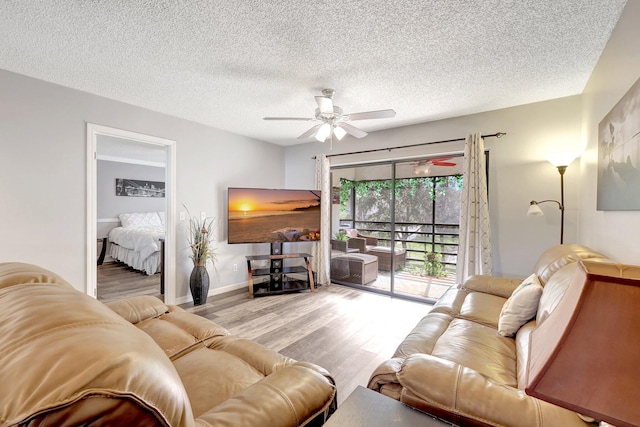 living room featuring a textured ceiling, light hardwood / wood-style flooring, and ceiling fan