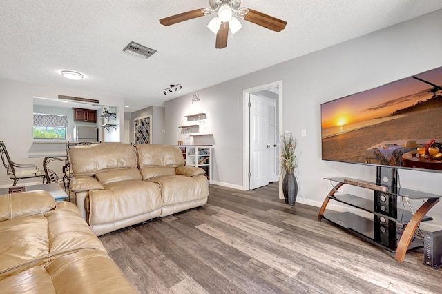 living room with ceiling fan, hardwood / wood-style floors, and a textured ceiling