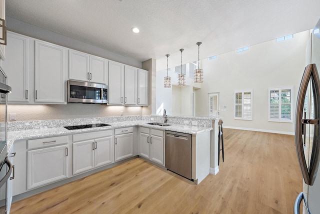 kitchen with white cabinets, stainless steel appliances, and hanging light fixtures