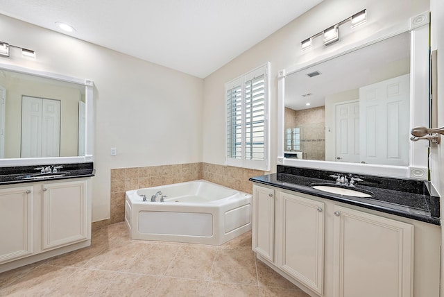 bathroom featuring vanity, a washtub, and tile patterned floors