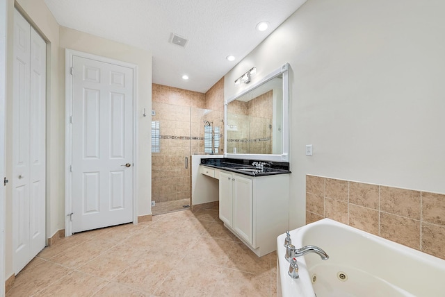 bathroom with shower with separate bathtub, a textured ceiling, tile patterned flooring, and vanity