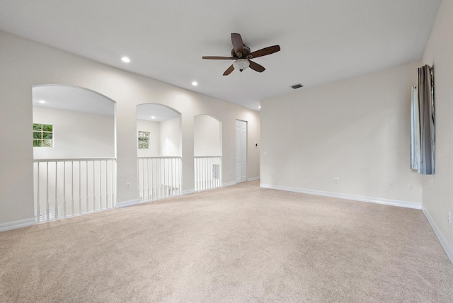 carpeted spare room featuring ceiling fan and plenty of natural light