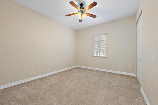 carpeted empty room featuring ceiling fan