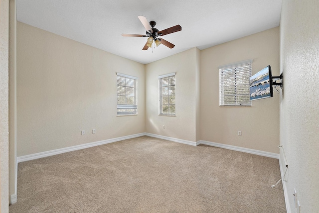 unfurnished room featuring ceiling fan and light carpet