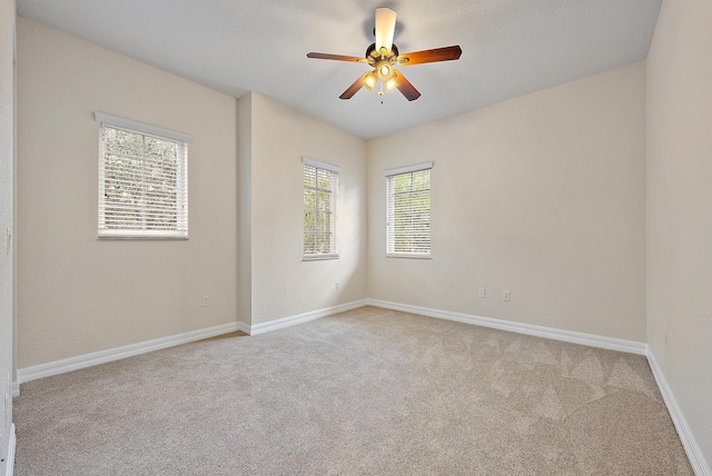 carpeted spare room with ceiling fan