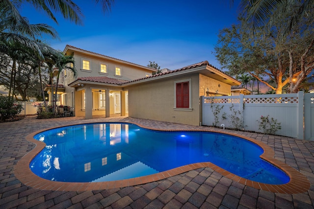 pool at dusk with a patio