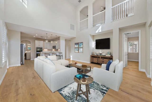 living room with light hardwood / wood-style floors and a high ceiling