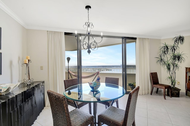 dining room with light tile patterned floors, ornamental molding, a chandelier, and a water view