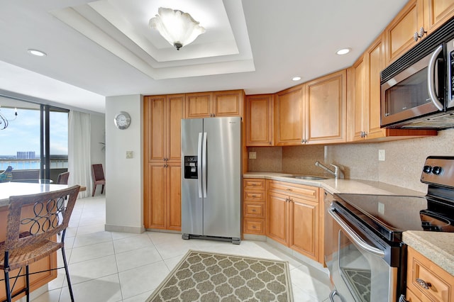 5080 N Ocean Dr Unit 20C, Riviera Beach, FL 33404 - kitchen with stainless steel appliances, a sink, light tile patterned floors, decorative backsplash, and a raised ceiling