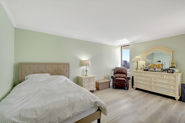 bedroom with ornamental molding and light hardwood / wood-style floors