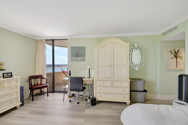 office space with light wood-type flooring, ornamental molding, and a water view