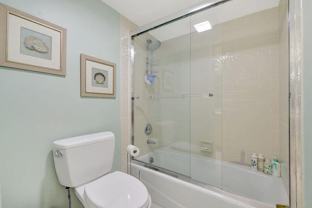 bathroom featuring shower / bath combination with glass door and toilet