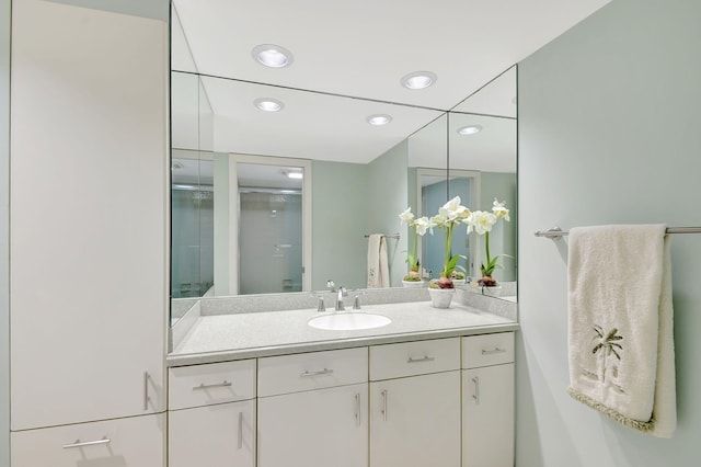 bathroom with vanity and a shower with door