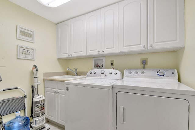 clothes washing area featuring sink, cabinets, and washing machine and clothes dryer