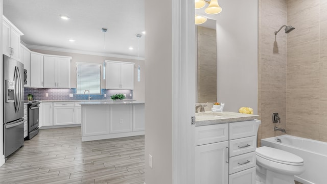 full bathroom with toilet, crown molding, vanity, tiled shower / bath combo, and backsplash