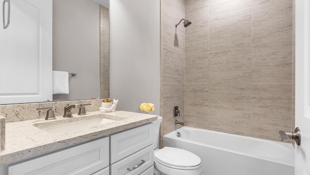 full bathroom featuring tiled shower / bath, vanity, and toilet