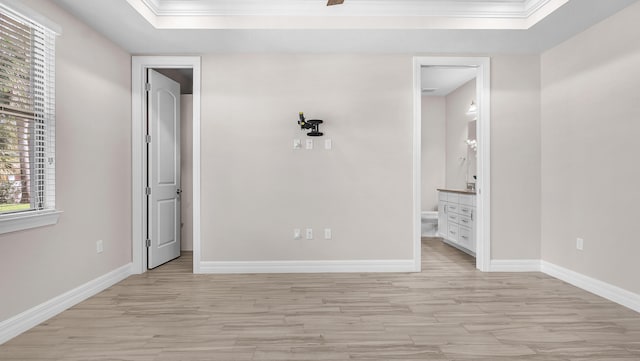 unfurnished bedroom featuring connected bathroom, crown molding, light hardwood / wood-style floors, and ceiling fan