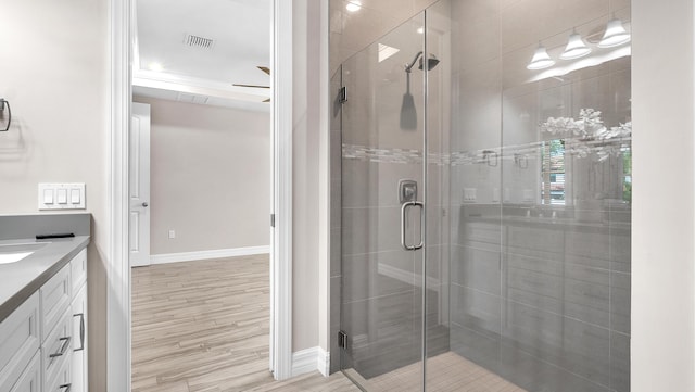 bathroom featuring hardwood / wood-style flooring, vanity, and a shower with shower door