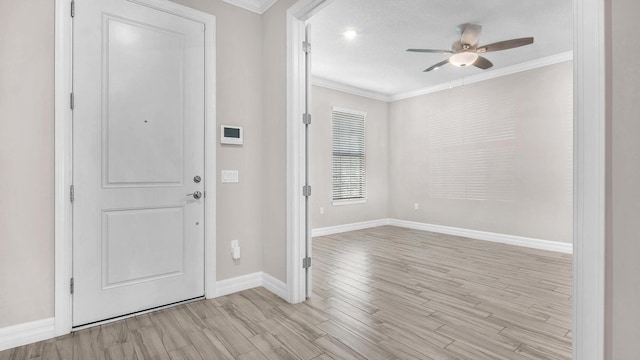 entrance foyer with crown molding, ceiling fan, and light wood-type flooring