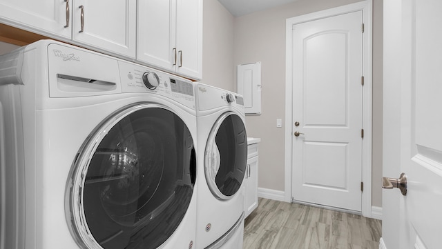 laundry room with cabinets, washing machine and clothes dryer, and light wood-type flooring