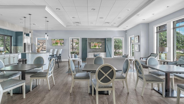 dining space with hardwood / wood-style flooring and a tray ceiling