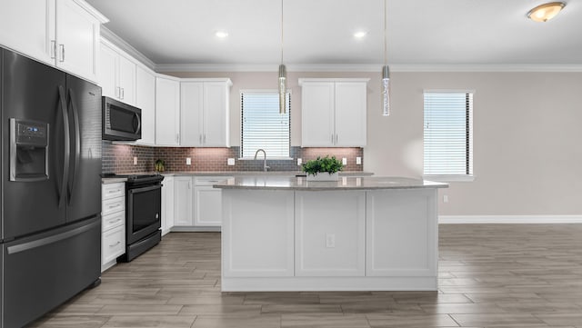 kitchen with white cabinets, black fridge, electric range, and light stone counters