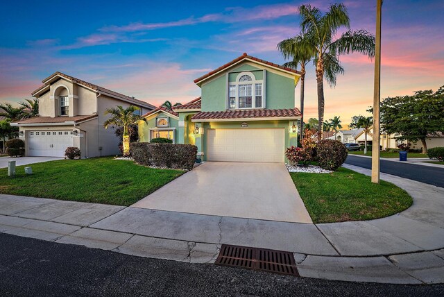 mediterranean / spanish-style house featuring a garage and a front yard