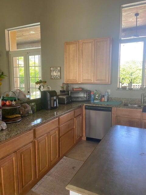 kitchen featuring dishwasher, plenty of natural light, sink, and light tile patterned flooring