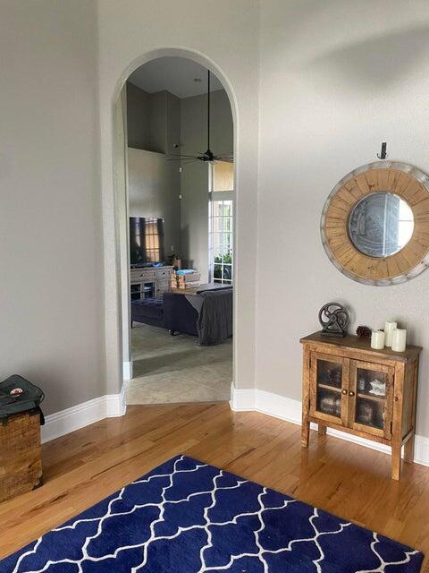 hallway with a towering ceiling and hardwood / wood-style floors