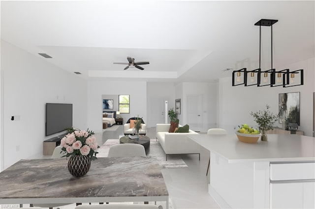 living room with ceiling fan, a raised ceiling, and visible vents