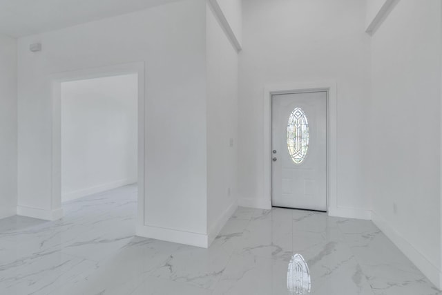 entrance foyer featuring marble finish floor and baseboards