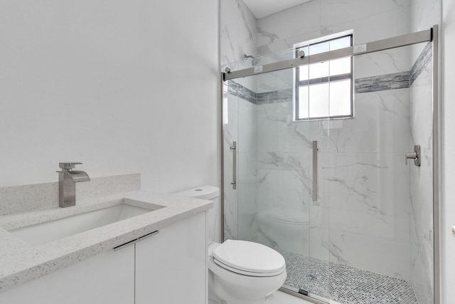 full bathroom with a marble finish shower, vanity, and toilet