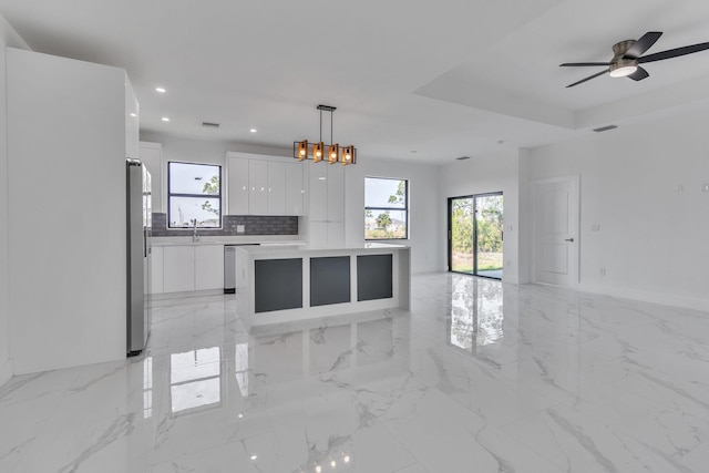 kitchen with a sink, visible vents, white cabinets, open floor plan, and appliances with stainless steel finishes