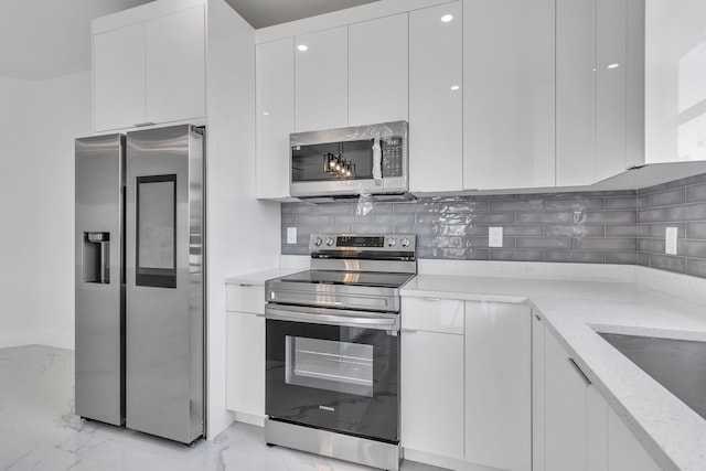 kitchen featuring marble finish floor, appliances with stainless steel finishes, modern cabinets, and white cabinetry