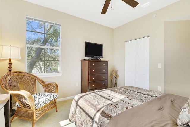 carpeted bedroom with multiple windows, ceiling fan, and a closet