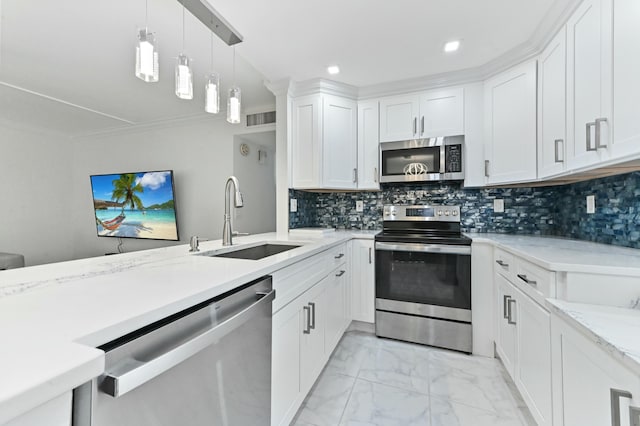 kitchen featuring white cabinetry, sink, decorative backsplash, hanging light fixtures, and stainless steel appliances