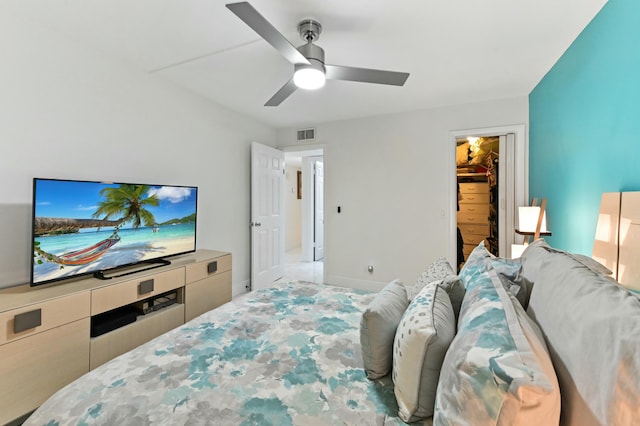 bedroom with a spacious closet, ceiling fan, and a closet