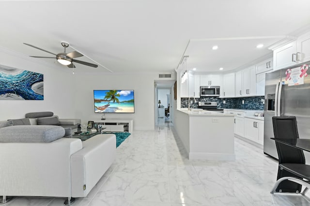 living room featuring ornamental molding, sink, and ceiling fan