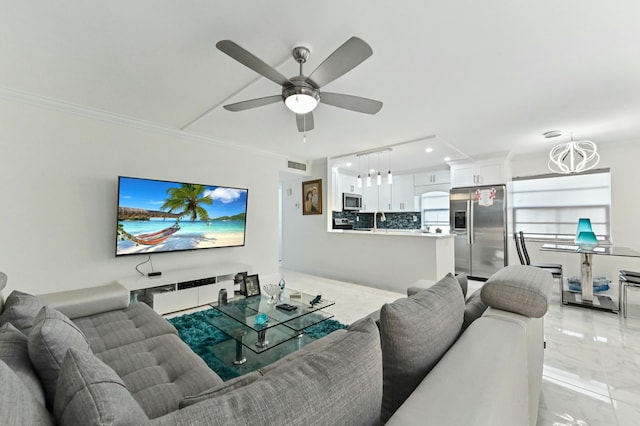 living room featuring crown molding, ceiling fan with notable chandelier, and sink