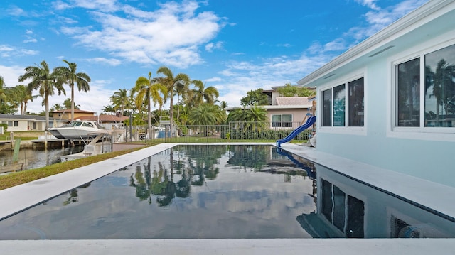 view of pool with a boat dock and a water view