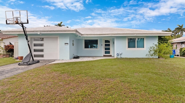 rear view of property with a garage and a lawn